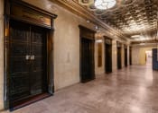 Thumbnail 17 of 18 - a hallway of elevators and doors in a building
