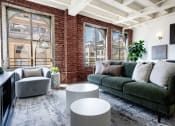 Thumbnail 4 of 18 - a living room with a green couch and a brick wall