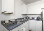 Thumbnail 2 of 20 - a kitchen with white cabinets and a stainless steel sink