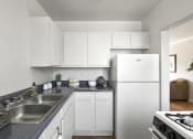 Thumbnail 1 of 20 - a white kitchen with a sink and a refrigerator