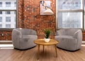 Thumbnail 14 of 21 - two chairs and a table in a room with a brick wall