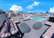 Thumbnail 18 of 21 - a roof top pool with furniture and a city in the background