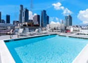 Thumbnail 17 of 21 - a rooftop pool with a city skyline in the background