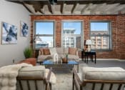 Thumbnail 1 of 21 - a living room with a couch and a brick wall