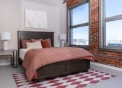 Thumbnail 12 of 21 - a bedroom with a bed and a brick wall