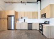 Thumbnail 36 of 57 - an empty kitchen with wooden cabinets and stainless steel appliances