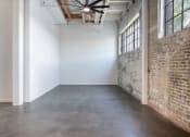 Thumbnail 37 of 57 - an empty room with a brick wall and a cement floor