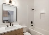 Thumbnail 46 of 57 - a bathroom with a sink and a tub and a mirror
