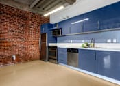 Thumbnail 13 of 24 - a kitchen with blue cabinets and a brick wall