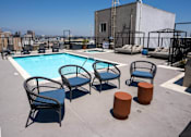 Thumbnail 15 of 24 - the pool at the top of a building with chairs