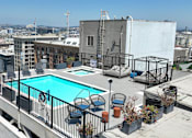 Thumbnail 17 of 24 - a swimming pool on the roof of a building with a city in the background