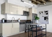 Thumbnail 3 of 24 - a kitchen with white cabinets and a table with chairs