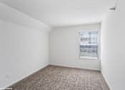 Thumbnail 11 of 52 - A room with a window and carpeted floor.