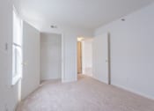 Thumbnail 22 of 52 - A white room with a carpet floor and a window on the left side.