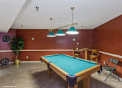 Thumbnail 27 of 52 - A pool table in a room with a brown wall.
