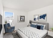 Thumbnail 3 of 52 - A bedroom with a large bed and a blue chair.