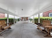 Thumbnail 42 of 52 - A long covered walkway with benches on either side.