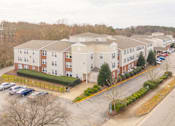 Thumbnail 52 of 52 - Apartment complex with a parking lot in front.