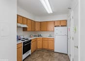 Thumbnail 5 of 52 - A kitchen with wooden cabinets and a white refrigerator.