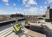 Thumbnail 20 of 50 - Rooftop patio with a fire pit and seating area at Archer Tower in Denver, CO