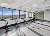 Thumbnail 32 of 50 - Exercise bikes with a stunning view in the fitness center at Archer Tower in Denver, CO