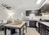 Thumbnail 11 of 50 - Open concept living area with wood-look plank flooring at Archer Tower in Denver, CO