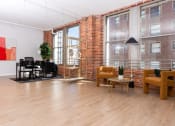 Thumbnail 7 of 19 - a living room with a brick wall and a wood floor