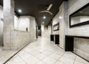 Thumbnail 16 of 19 - a large marble hallway in a public restroom with a ceiling fan