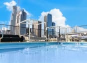 Thumbnail 13 of 19 - a swimming pool with a city skyline in the background