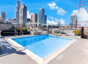 Thumbnail 14 of 19 - the pool on the roof of a building with a city in the background