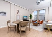 Thumbnail 2 of 19 - a living room and dining room with a table and chairs