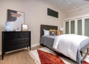 Thumbnail 10 of 19 - a bedroom with a bed and a dresser