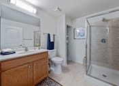 Thumbnail 29 of 42 - A bathroom with a toilet, sink, and shower.
