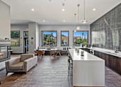Thumbnail 40 of 42 - A modern kitchen with a large island and a dining table with chairs.