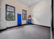 Thumbnail 38 of 42 - A room with a blue exercise machine and a red ball.