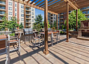 Thumbnail 35 of 42 - A wooden pergola with a fireplace is in the middle of a patio.
