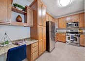 Thumbnail 16 of 42 - A kitchen with wooden cabinets and a blue chair.