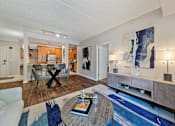 Thumbnail 14 of 42 - A living room with a white couch, a coffee table, and a blue rug.
