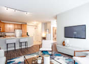 Thumbnail 26 of 42 - A modern living room with a white couch and a television on the wall.