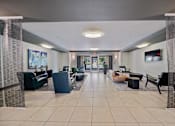 Thumbnail 41 of 42 - A spacious waiting area with a variety of seating options and a television mounted on the wall.