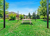 Thumbnail 36 of 42 - A park with a bench and trees.