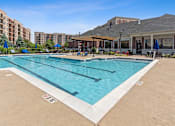 Thumbnail 34 of 42 - A large outdoor swimming pool with a building in the background.