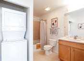 Thumbnail 30 of 42 - A white washing machine is in a small laundry room.