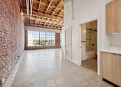 Thumbnail 17 of 57 - A room with a brick wall and wooden cabinets.