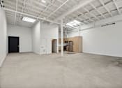 Thumbnail 19 of 57 - A large empty room with a white ceiling and walls.