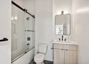 Thumbnail 23 of 57 - A white toilet sits next to a sink in a bathroom.