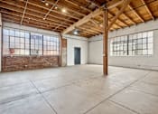 Thumbnail 28 of 57 - A large, empty room with wooden beams and white walls.