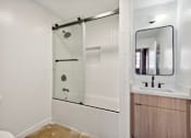 Thumbnail 29 of 57 - A bathroom with a toilet, sink, and a glass shower stall.