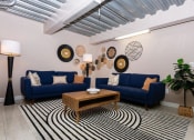 Thumbnail 9 of 16 - a living room with two blue couches and a coffee table