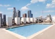 Thumbnail 11 of 16 - a pool on the roof of a building with a city in the background